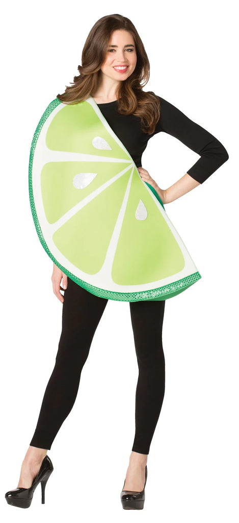 Woman posing in the Adults Lime Slice Costume Featuring a foam-style tunic designed in a large half-circle lime slice shape, with a bright green outer rind, lighter green interior segments, white dividing lines, and printed juice droplet details