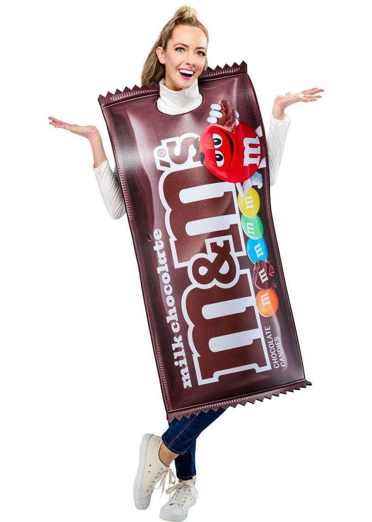 Woman posing in the Adults Milk Chocolate M&M's Costume Featuring a foam-backed tunic costume designed to resemble a milk chocolate M&M’s candy package, with a rich brown wrapper print, large white m&m’s branding across the front, printed colorful candy pieces along the side, jagged wrapper-edge detailing at the top and bottom, and an open, sleeveless design with side ties for an adjustable and comfortable fit over everyday clothing.