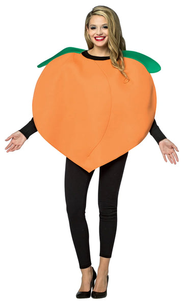 Woman posing in the Adults Pleasant Peach Costume Featuring a large orange poly-foam tunic shaped like a rounded peach with a smooth surface, subtle center seam detail, and two attached green leaf accents at the neckline, designed in a loose, wearable silhouette that slips on easily over clothing.
