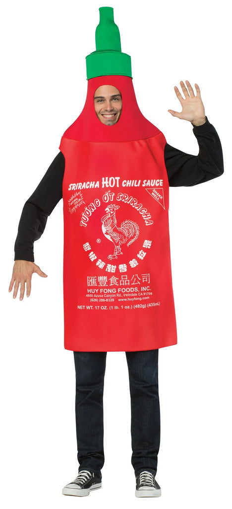 Man in the Adults Sriracha Hot Chili Sauce Costume Featuring a red polyester tunic designed to resemble a classic Sriracha hot chili sauce bottle, with a tapered top and an attached green nozzle cap, printed on the front with detailed white label graphics including text and rooster emblem, along with a face opening near the top and wide arm openings at the sides for easy wear.