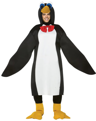 Man in the Adults Penguin Costume Featuring a black and white penguin tunic with a smooth fabric finish, designed with a white front panel and attached elongated wing-style sleeves. The costume includes an attached hood with a sculpted penguin beak and large cartoon-style eyes, along with a red bow tie at the neckline. Matching yellow penguin feet shoe covers slip over footwear, completing the look with webbed detailing and a soft, rounded shape.
