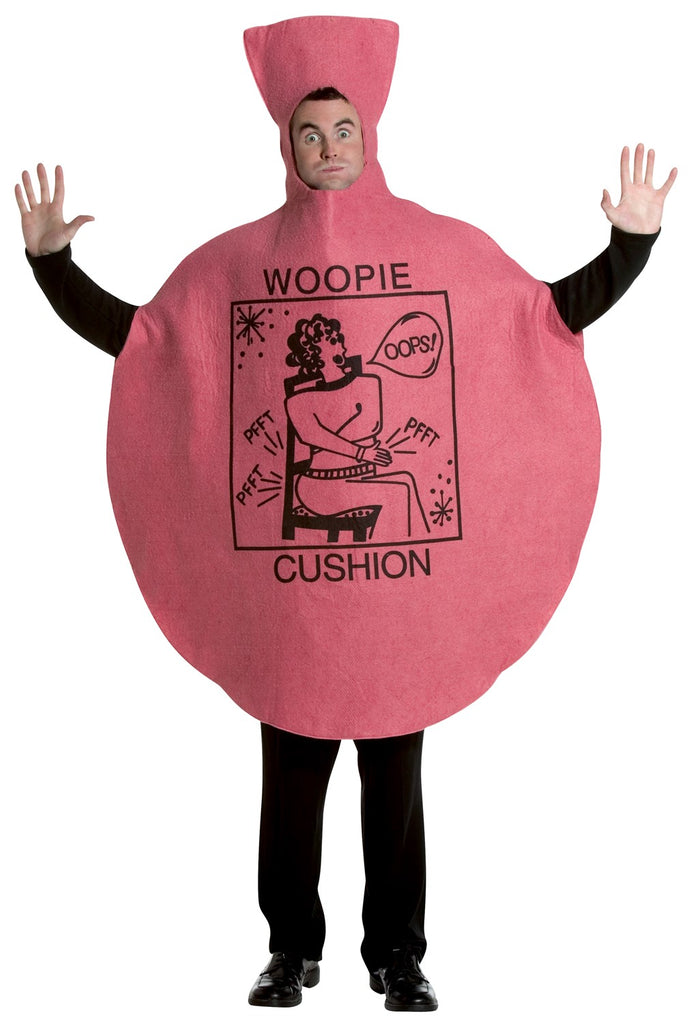 Man in the Adults Whoopee Cushion Costume Featuring a one-piece oversized cushion-shaped tunic in a pink felt-like fabric with a rounded, inflated silhouette and a tall nozzle-style top. The front displays printed black artwork including the words woopie cushion and a cartoon-style illustration with small text details and graphic elements. The design includes a face opening at the upper center and wide side openings for arms
