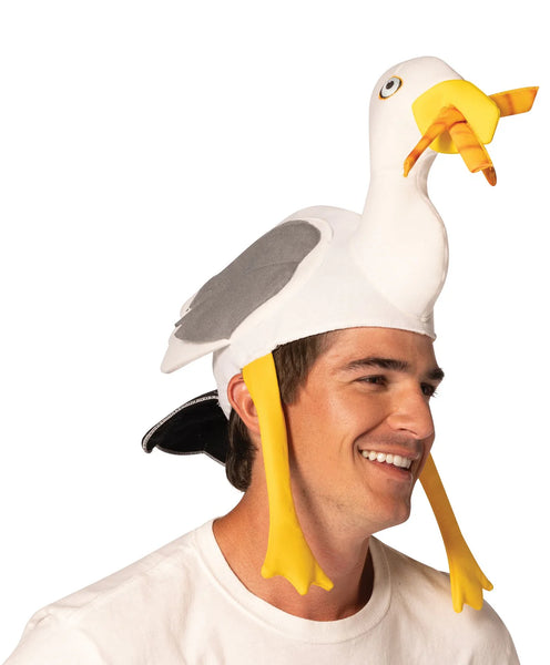 Man modeling the Boardwalk French Fry Thief Seagull Hat Featuring a foam headpiece shaped like a seagull with a white body, gray wing panels on each side, and a sculpted head with a long neck, detailed with a yellow beak holding soft 3D French fries, round printed eyes, and dangling yellow legs that hang down along the sides for added movement and dimension.