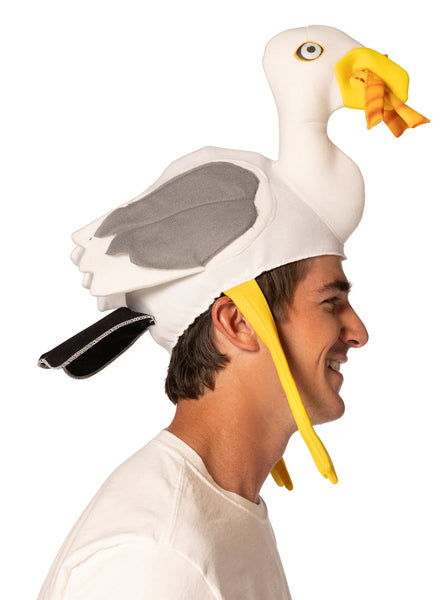 Side view of Man modeling the Boardwalk French Fry Thief Seagull Hat Featuring a foam headpiece shaped like a seagull with a white body, gray wing panels on each side, and a sculpted head with a long neck, detailed with a yellow beak holding soft 3D French fries, round printed eyes, and dangling yellow legs that hang down along the sides for added movement and dimension.