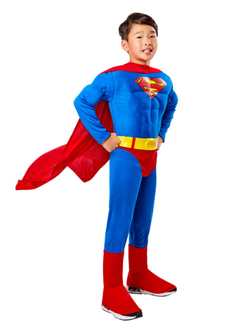 Boy wearing DC Universe Deluxe Muscle Superman Costume
Featuring a bright royal‑blue jumpsuit with built‑in padded muscle chest and arms, giving a bold superhero physique, the iconic red and yellow Superman “S” shield printed on the chest, detachable flowing red cape, and vibrant red boot‑top covers, front view