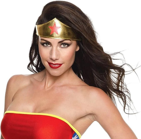 Woman wearing the Wonder Woman tiara costume accessory featuring a metallic gold‑tone headpiece designed with a smooth, slightly arched band that curves across the forehead; centered with a bold red star emblem that stands out vividly against the reflective gold surface. The tiara is finished with an elastic strap at the back for a secure fit, allowing it to sit comfortably while maintaining its iconic superhero shape