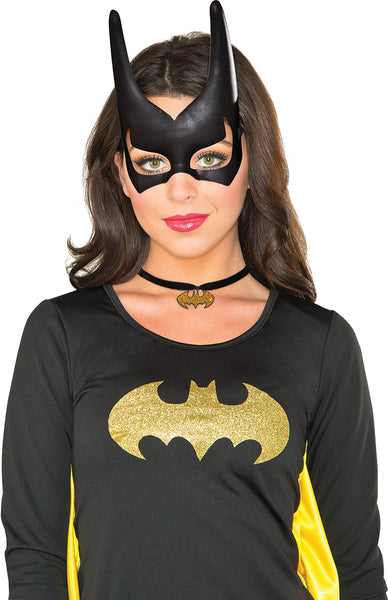 Woman wearing the Batgirl mask featuring a sleek molded black half‑face mask crafted from smooth plastic, designed with tall, sharply pointed bat ears that extend upward for a dramatic silhouette; includes cleanly cut eye openings and subtle contouring around the nose bridge and brow for a snug, structured fit. The mask is finished with elastic side straps that secure around the head, maintaining the classic Batgirl shape while keeping the design simple and bold