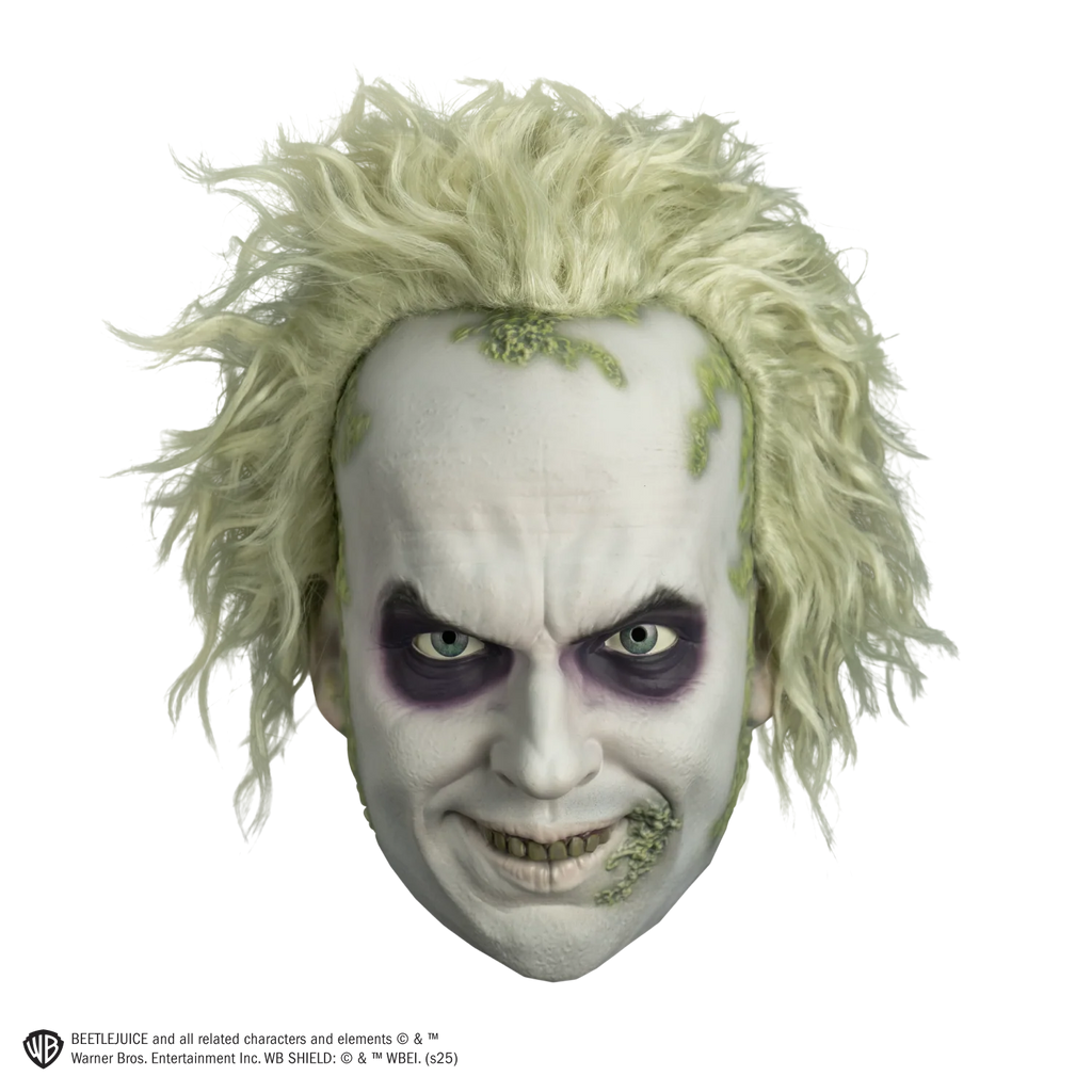 Deluxe Beetlejuice Injection Costume Mask features a gnarly yellow‑green complexion, pale, white cheeks and complexion, a wide crooked grin packed with uneven, decayed yellow teeth, eyes rimmed with dark purple bags and shading, heavy wrinkle lines across the brow and mouth, and moss like details along the side of the mouth and hairline with matching wild, frizzy green hair attached, front view