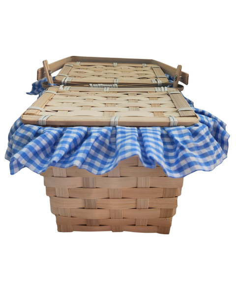 A woven natural wood basket with two matching lids, draped with a blue and white checkered gingham trim
