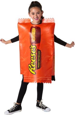 Girl modeling the Kids Hershey Reese's Peanut Butter Cup Costume featuring a bold, oversized tunic designed to resemble a classic Reese’s wrapper, printed in vibrant orange with large yellow “Reese’s” lettering and a detailed image of a sliced peanut butter cup at the top; styled with crimped “wrapper” edges at the neckline and hem for a realistic candy‑bar effect. The lightweight, sleeveless design slips easily over clothing, creating a full‑body candy package silhouette that’s instantly recognizable