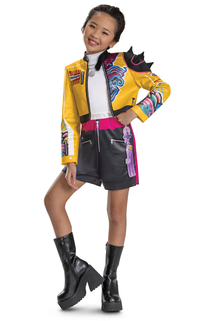Girl wearing Girls K-Pop Demon Hunters Rumi Costume Features a cropped yellow jacket with black trim and vibrant printed graphics across the sleeves and chest, paired with coordinating romper with black shorts accented by a bright pink waistband and zipper detail, and white top. The jacket is styled with dramatic elements like a sculpted spiked shoulder piece and layered printed designs in teal, purple, and multicolor patterns.