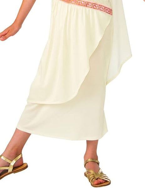 A girl posing showing the bottom of the Girls Roman or Greek Toga Costume which features a classic one‑shoulder white toga‑style dress designed with a softly draped, flowing silhouette, accented with elegant pink and gold Greek‑key trim bands across the shoulder strap, bodice, and waistline that add structure and visual contrast. The look is completed with a matching gold‑tone leaf headband that sits across the forehead, reinforcing the traditional ancient‑world aesthetic