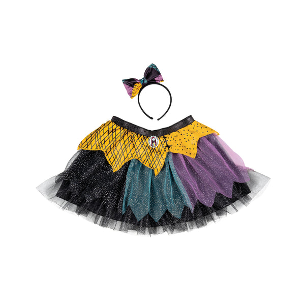 Girls The Nightmare Before Christmas Sally Tutu and Headband Costume Accessory Kit Features a two‑piece set inspired by Sally, including a layered tutu skirt and coordinating headband with bow detail. The skirt is designed with mixed‑color panels of black, teal, purple, and yellow mesh fabric, arranged in uneven, patchwork‑style layers with a light shimmer finish. The waistband is finished with a sparkled black band and a small Sally character cameo at the front. The headband includes a matching bow