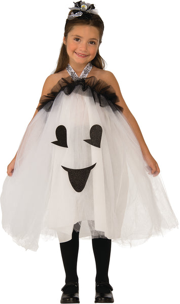 Girl posing in the Girls Ghost Gal Tutu Dress Costume featuring a ballerina‑style white tutu dress designed with layers of soft white tulle; the front of the dress is decorated with a friendly glitter‑black ghost face graphic, including happy eyes and a smiling mouth. The neckline is finished with a black tulle ruffle trim, attached to a halter‑style neck strap printed with black‑and‑white swirl accents. The look is completed with a coordinating black‑and‑white bow headband with a small ghost 