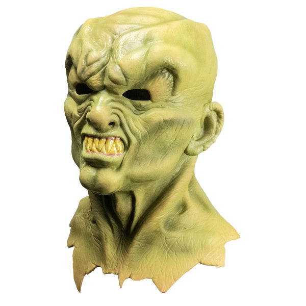 Goosebumps The Haunted Mask Costume Mask features a sickly yellow‑green latex finish, darker olive shading for an aged, cursed look, deep hollow black eye openings, exaggerated cheek contours, a stretched twisted smile with shadowed wrinkles, flared nostrils, and smooth rounded edges, left profile