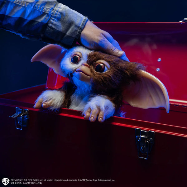 Gremlins Gizmo Mogwai Costume Prop Doll features a screen inspired doll with oversized, posable ears, foam body with posable wire skeleton frame, expressive, inserted eyes, soft facial features, fluffy, brown and cream toned texturing, and Gizmo's signature but sweet-but-mischievous look, cinematic image
