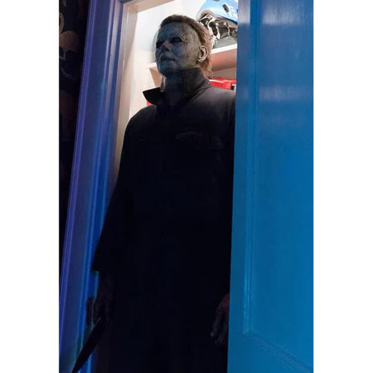 Halloween 2018 Movie Michael Myers Costume Mask features a screen accurate, latex, sculpt with aged, pale, lifeless finish, cut and weathered details, and rooted brown hair, cinematic view in closet with blue doors