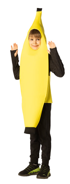 Boy in Kids Banana Costume Featuring a bright yellow banana-shaped tunic with a smooth fabric finish and a curved silhouette that tapers toward the top and bottom, accented by dark brown tips to mimic a real banana peel. The costume includes a front oval face opening and wide arm openings