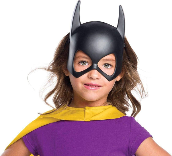 Girl wearing the DC Universe Batgirl Mask featuring  a molded black half‑face mask crafted from smooth, lightweight plastic, designed with Batgirl’s signature pointed bat ears extending upward from the top of the mask; styled with clean, angular eye openings and a gently contoured nose bridge for a snug, heroic fit. The matte black finish creates a sleek, uniform appearance, instantly capturing the recognizable Batgirl silhouette from the DC Universe