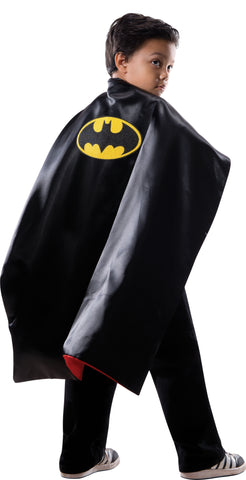 Boy wearing the Kids DC Universe Batman and Superman Reversible Cape Costume Accessory on the Batman side featuring a solid black with a large yellow Batman bat emblem centered on the back