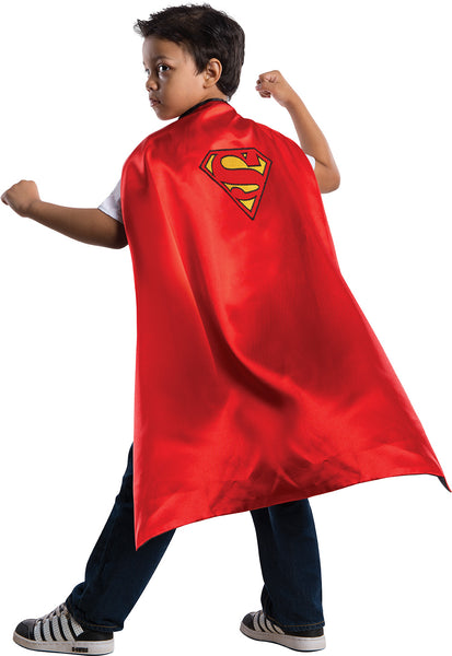 Boy wearing the Kids DC Universe Batman and Superman Reversible Cape Costume Accessory on the Superman side featuring bright red with the classic Superman “S” shield printed in yellow and red