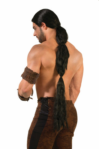 Man modeling Medieval Fantasy Warrior Costume Wig which features long, synthetic hair styled into a thick, low ponytail that extends well down the back; designed with a smooth, pulled‑back crown and tight side sections that keep the hair close to the head before gathering into the heavy trailing length; finished with subtle texture variation through the tail to create a rugged, battle‑ready silhouette and wearing brown arm guards and pants 