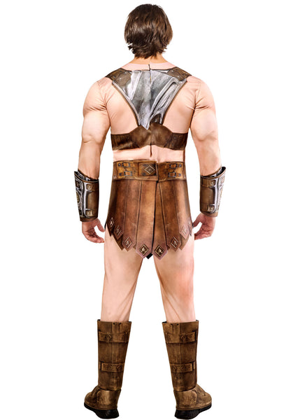 Back view of man in the Mens Deluxe Masters Of The Universe He-Man Costume Featuring a full-body costume set including a flesh-toned jumpsuit with built-in muscle padding on the chest, arms, and legs, a molded chest armor piece with metallic detailing and a red cross emblem at the center, a brown faux leather-style loincloth skirt with stitched panel accents, coordinating arm bracers, a wide belt with buckle detail, and tall boot tops designed to create a cohesive armored warrior look.