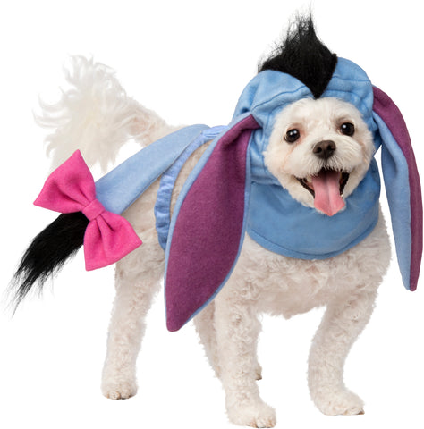 A Small dog wearing Pets Disney Winnie the Pooh Eeyore Costume Accessory Kit featuring a soft fabric headpiece designed to resemble Eeyore’s gentle donkey face, complete with long floppy ears, subtle stitched facial details, and a muted blue‑gray color palette that captures the classic character look; paired with a lightweight attached tail accessory finished with Eeyore’s signature pink bow