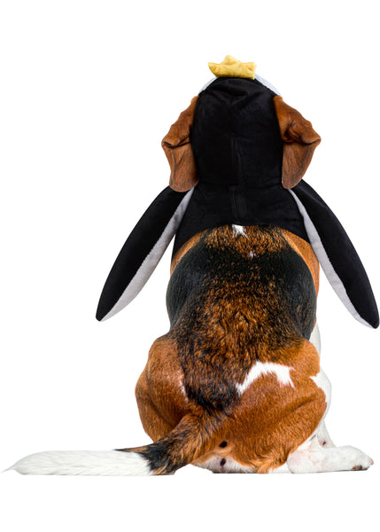 Beagle dog modeling back view of Pets Walking Penguin Costume which features a plush, full‑body penguin "walking" illusion in classic black‑and‑white coloring with a soft white belly panel, black flipper‑style sides, and oversized yellow plush feet and an attached penguin character hood with embroidered eyes, a soft yellow beak, and a bright yellow crown perched on top, along with a red‑and‑white checkered bow tie