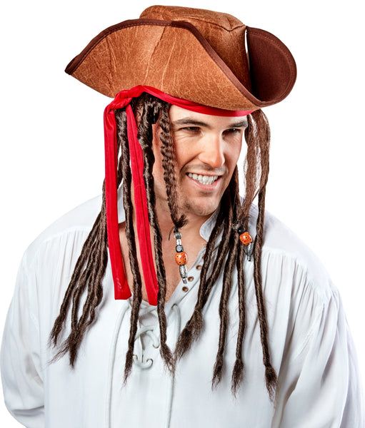 Man grinning while wearing Pirate Hat with Dreads Costume Hat featuring a weathered brown tricorn‑style pirate hat with a textured, leather‑look finish and stitched edging along the brim; accented with a wrapped red fabric band tied around the hat, from which long dark brown faux dreadlocks hang down on both sides; several of the dreadlocks are decorated with small bead details in metallic silver and amber tones, side view