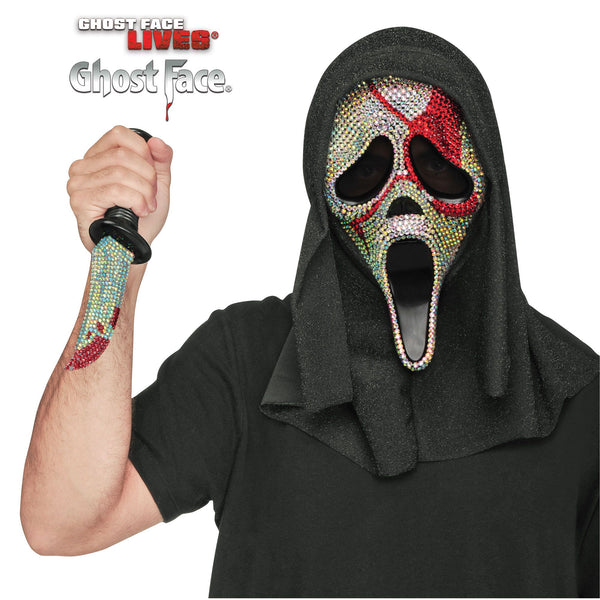 Man modeling the Scream Ghost Face Bloody Bling Costume Mask and Knife Set featuring a dramatic Ghost Face mask covered in sparkling rhinestone‑style embellishments, detailed with bold red “blood splatter” accents layered over the bling for a striking contrast. The mask includes an attached black hooded drape for a classic silhouette, and is paired with a matching molded plastic knife prop featuring a silver‑tone blade with red blood detailing and a black handle, completing the coordinated slasher look