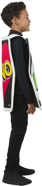 Side view of a boyin the Kids Mattel Uno Card Game Draw Four Card Costume featuring a tunic designed to look like the iconic UNO Draw Four card, with a black background bordered in white and a large white oval at the center; the card face is printed with four colorful card symbols in blue, green, yellow, and red, along with the “+4” markings in the corners, recreating the instantly recognizable look straight from the game