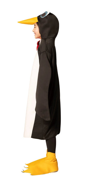 Side of Teenager in the Teens Penguin Costume Featuring a black and white penguin tunic made from lightweight fabric, designed with a white front panel and black back and sides that create a classic penguin color pattern. The costume includes an attached hood with a yellow beak and large stylized eyes, along with a red bow tie at the neckline. The long wing-like sleeves have openings that allow hands to come through, and matching yellow flipper-style shoe covers complete the look.