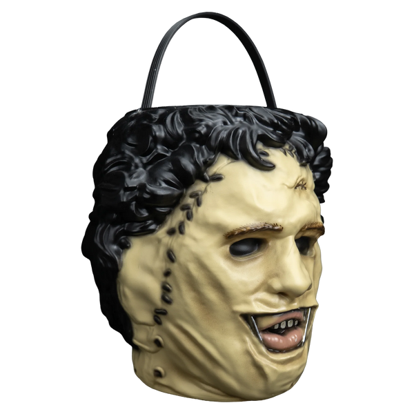 The Texas Chainsaw Massacre Leatherface Candy Treat Pail Bucket
features a molded plastic bucket sculpted to resemble Leatherface’s stitched human‑skin mask, with pale flesh tones, darker seam lines, rough texturing to mimic worn skin, hollow eye holes, a slack unsettling mouth, and an integrated carrying handle, right profile