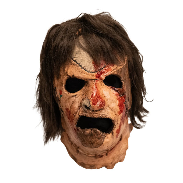 The Texas Chainsaw Massacre 3 III Leatherface Costume Mask of a latex full-head Leatherface mask with grimacing expression, stitched skin details, bloody patches, little rose heart tattoo on the cheek, and attached hair, front view