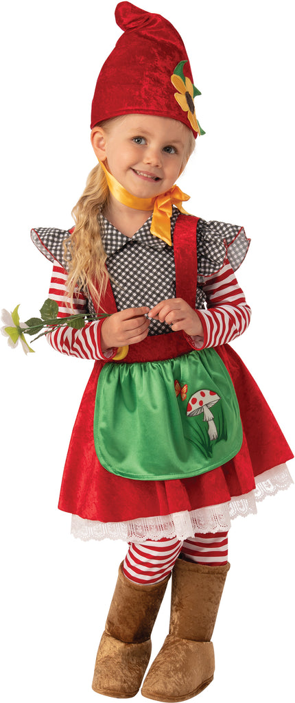 Toddler posing in Girls Garden Gnome Costume which features a whimsical storybook‑style outfit with a rich red velvet‑look dress layered over a long‑sleeve red & white striped shirt, creating a charming cottage‑garden silhouette; designed with a green satin apron at the front decorated with playful woodland mushroom artwork, trimmed with red edging and tied at the waist. The look is completed with a tall pointed red gnome hat accented with a yellow flower detail, striped leggings, and soft brown boot covers