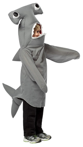 Child wearing the Toddlers Hammerhead Shark Costume Featuring a gray polyester tunic with a soft, smooth finish, designed with attached side fins, a rear tail, and an integrated hood shaped like a hammerhead shark head with wide-set eyes and an open mouth opening for the face, creating a full character silhouette in one easy-to-wear piece.