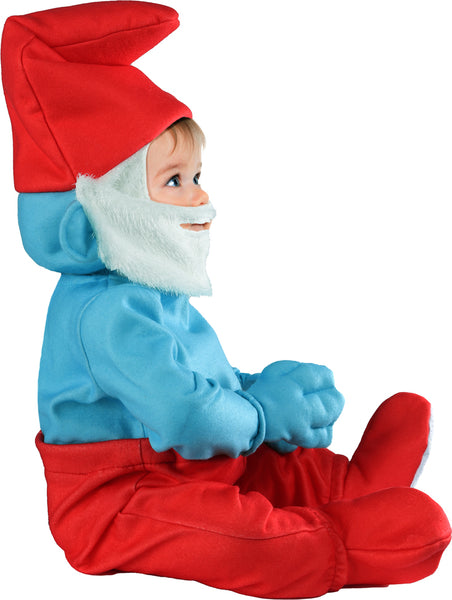 Side profile of toddler wearing Baby modeling the Toddlers The Smurfs Papa Smurf Costume featuring a one‑piece jumpsuit with a bright blue long‑sleeve upper section with attached hand covers and red pants with attached shoe covers, and topped off with the signature red Papa Smurf hat with an attached long white beard
